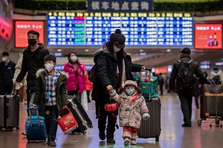 Một gia đình Trung Quốc về quê ăn Tết tại ga đường sắt thủ đô Bắc Kinh. Ảnh: AFP