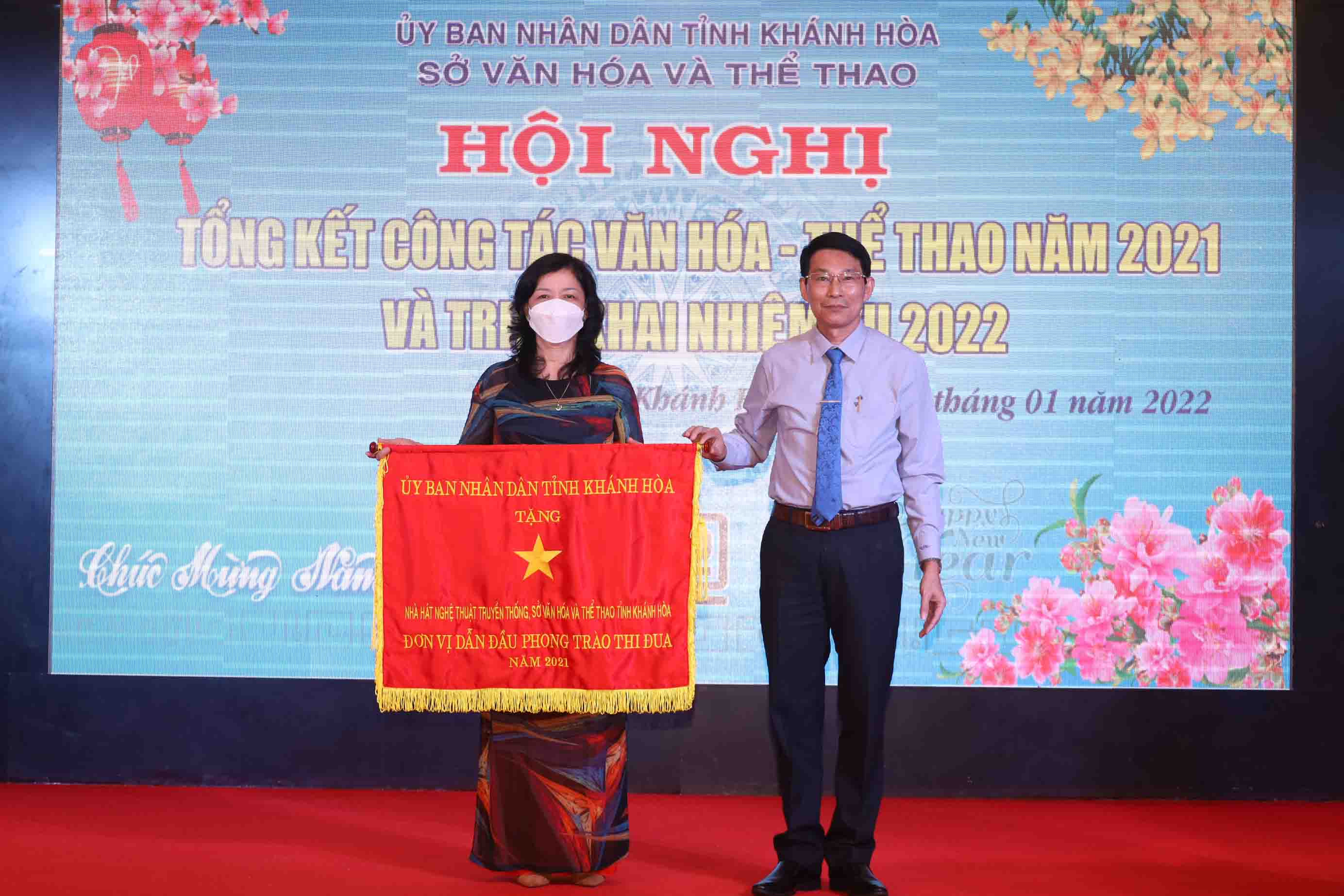 Ông Đinh Văn Thiệu trao cờ thi đua của UBND tỉnh cho đại diện Nhà hát Nghệ thuật truyền thống tỉnh Khánh Hòa.