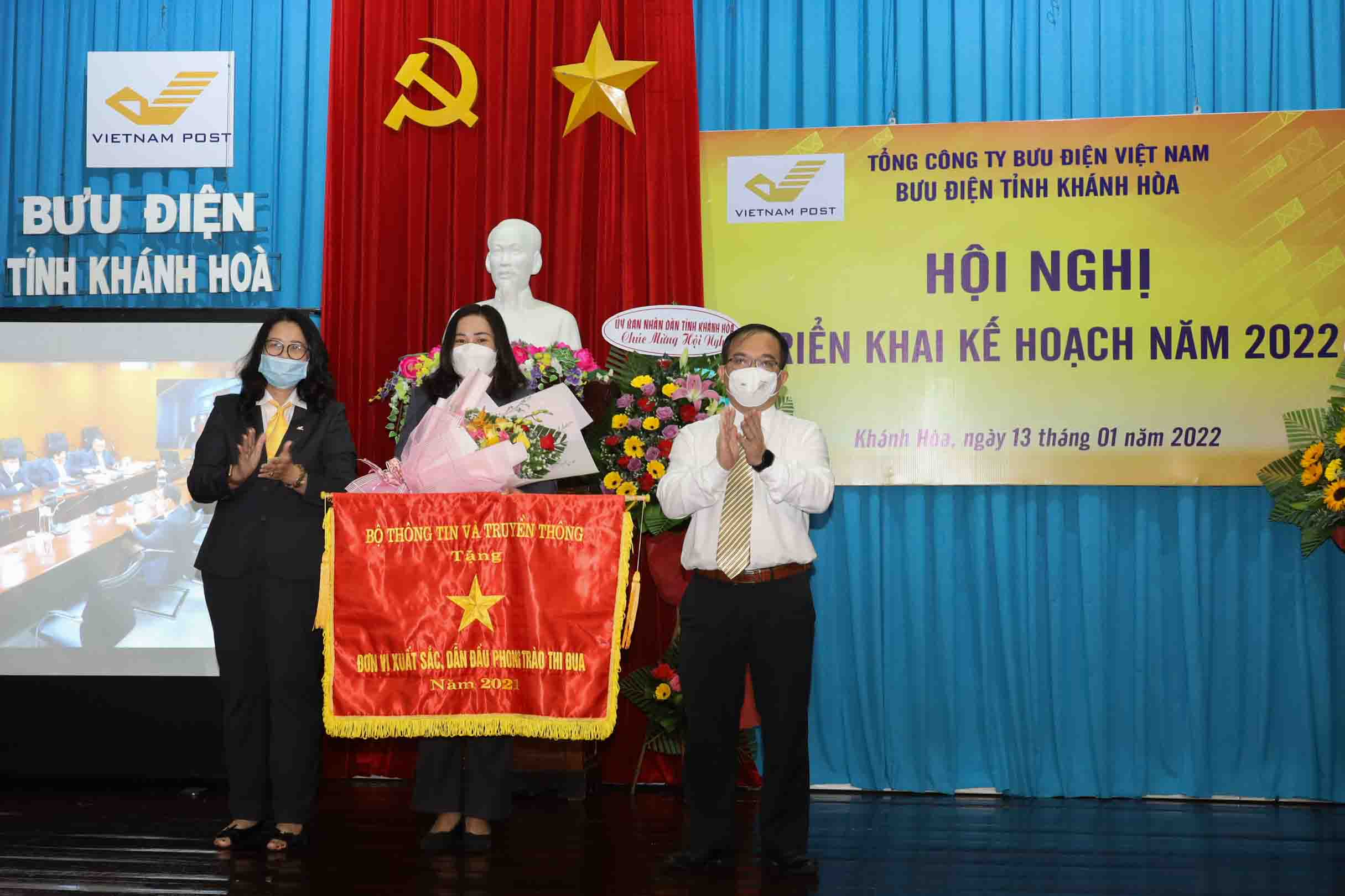 Đại diện lãnh đạo Sở Thông tin và Truyền thông, Bưu điện tỉnh Khánh Hòa thừa ủy quyền trao cờ thi đua của Bộ Thông tin và Truyền thông cho Bưu điện huyện Vạn Ninh. 