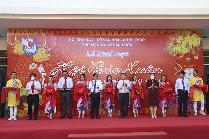 Các đại biểu thực hiện nghi thức cắt băng khai mạc Hội báo xuân Nhâm Dần 2022. 
