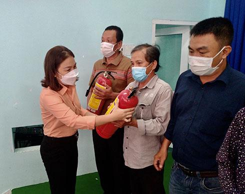 Bà Nguyễn Thị Cẩm Nhung - Chủ tịch UBMTTQ Việt Nam phường Van Thắng trao bình chữa cháy cho các hộ gia đình
