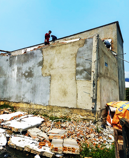 Lực lượng chức năng cưỡng chế tháo dỡ  công trình xây dựng trái phép trên đất công  tại thôn Phước Lộc. 