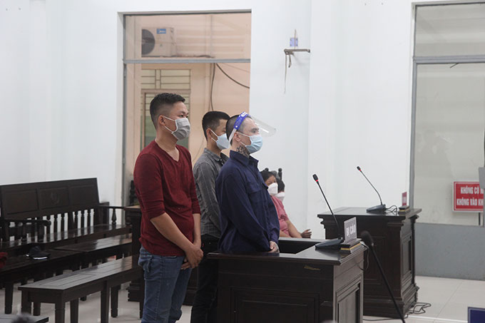 Bị cáo Trần Thanh Bình (đứng, hàng đầu) cùng các bị cáo tại tòa.