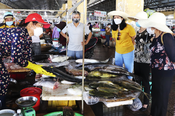 Khách du lịch mua cá tại chợ Vĩnh Hải (TP. Nha Trang).