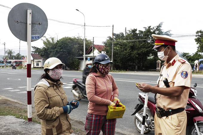 Cán bộ Đội tuần tra kiểm soát giao thông Ninh Hòa kiểm tra giấy tờ liên quan đối với người điều khiển phương tiện.