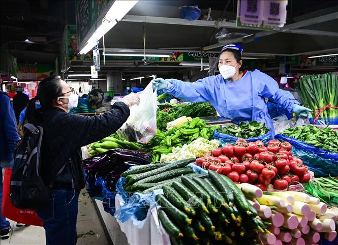 Người dân đeo khẩu trang phòng dịch COVID-19 tại khu chợ ở Thượng Hải, Trung Quốc, ngày 9/5/2022. Ảnh: THX/TTXVN