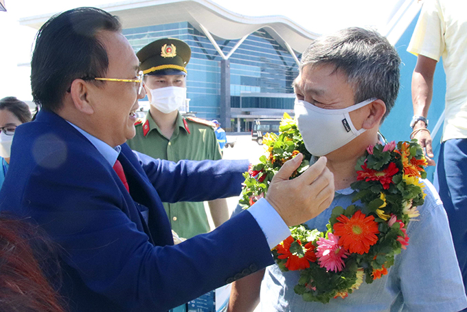 Ông Lê Hữu Hoàng tặng hoa cho du khách trên chuyến bay Singapore – Cam Ranh.