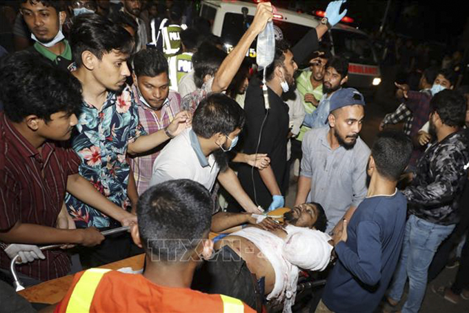 Lực lượng cứu hộ chuyển các nạn nhân tại hiện trường vụ cháy nổ kho chứa container ở thị trấn Sitakunda, cách cảng biển lớn Chittagong, miền Đông Nam Bangladesh, khoảng 40km, đêm 4/6/2022. Ảnh: AFP/TTXVN