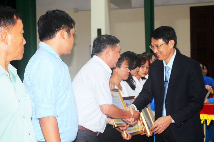 Ông Đinh Văn Thiệu - Phó Chủ tịch UBND tỉnh (bìa phải) tặng bằng khen của UBND tỉnh cho các gia đình.