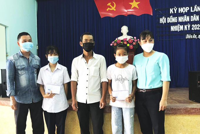 Em Nguyễn Thái Phương Uyên (thứ 2 từ trái qua) nhận tiền hỗ trợ của Tổ chức Holt.