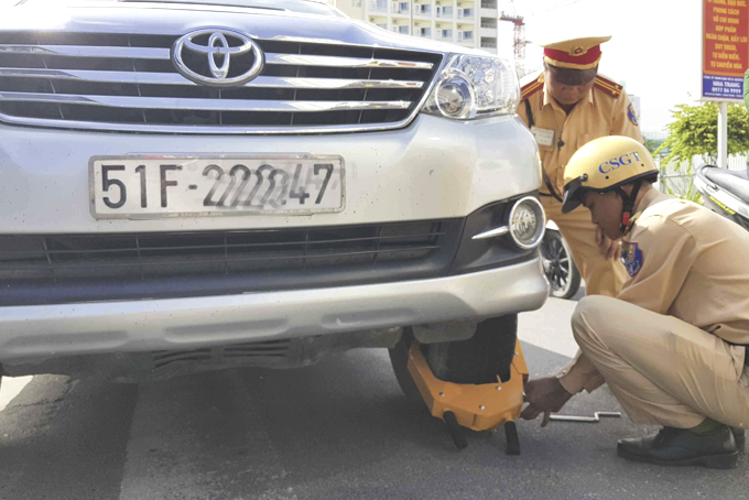 Lực lượng Cảnh sát giao thông TP. Nha Trang cùm khóa bánh xe ô tô đỗ sai quy định.