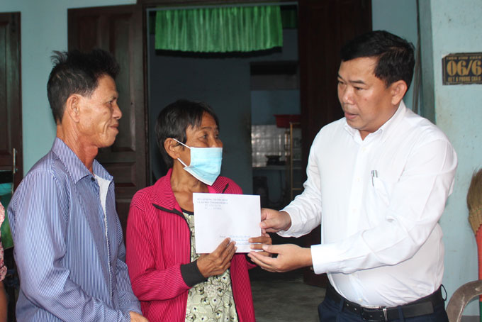 Ông Nguyễn Thành Sơn (bên trái) trao trợ cấp khó khăn đột xuất cho bà Phạm Thị Thanh Thủy.