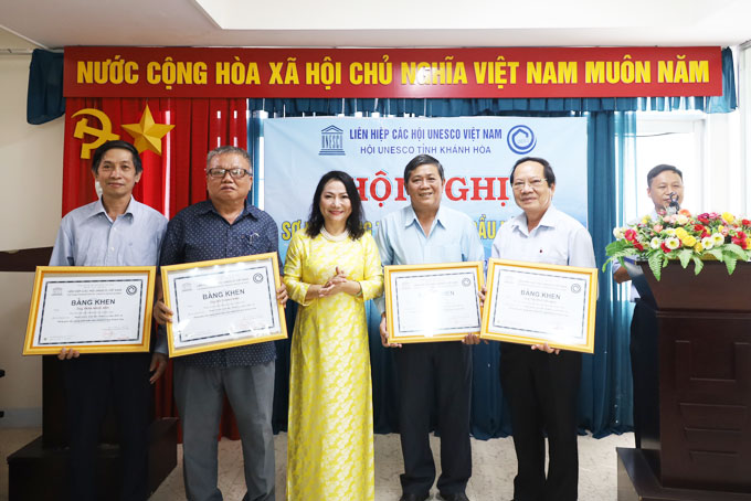 Lãnh đạo Hội UNESCO tỉnh Khánh Hòa trao bằng khen của Liên hiệp các Hội UNESCO Việt Nam cho một số hội viên. 