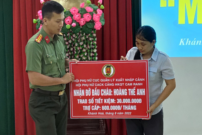 Đại diện Công an cửa khẩu Cảng Hàng không quốc tế Cam Ranh trao tượng trưng sổ tiết kiệm cho gia đình Đại úy Hoàng Văn Yên.